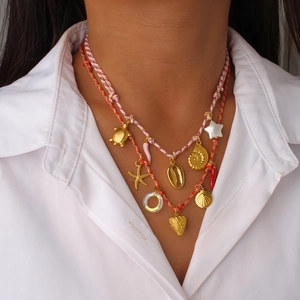 Collier multicouche bohème avec cordes colorées et divers pendentifs marins dorés