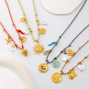 Détail de colliers en corde nouée colorée avec pendentifs en or 18 carats et style plage