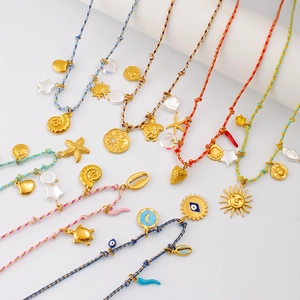 Détail de colliers bohèmes en corde tressée avec coquillages dorés et pendentifs étoiles