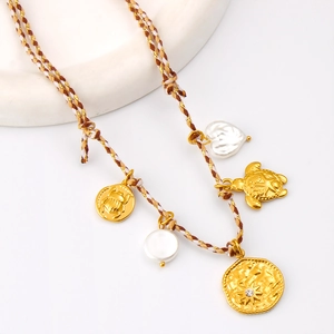 Détail du collier bohème avec breloques scarabée et tortue dorées et pendentif soleil étoilé