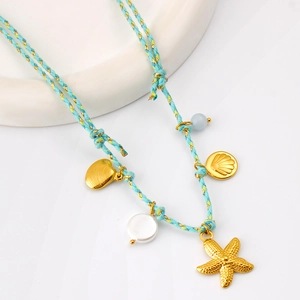 Gros plan du collier en corde tressée océan avec pendentifs étoile de mer et coquillage dorés