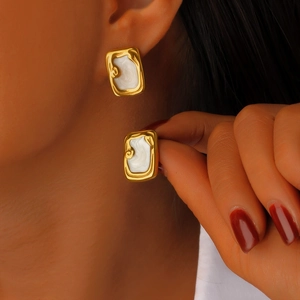 Gros plan détaillé de boucles d'oreilles rectangulaires en or 18K et émail blanc