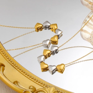 Detail der ineinandergreifenden Gold- und Silber-Herzanhänger an einer 18K Goldkette
