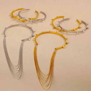 Dettaglio di bracciali a rivetti multistrato in oro e argento con frange metalliche