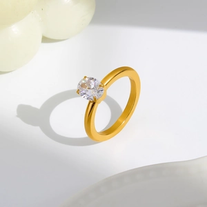 Detailed view of an oval-cut clear zircon stone with 4-prong setting on a gold ring band