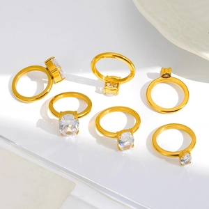 Detailed view of six gold-plated rings set with sparkling oval and round zircons