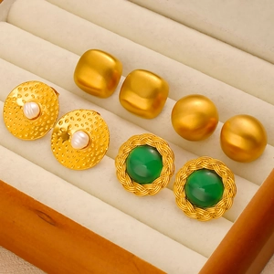 Detail of four vintage geometric stainless steel earrings with gold plating and zircons
