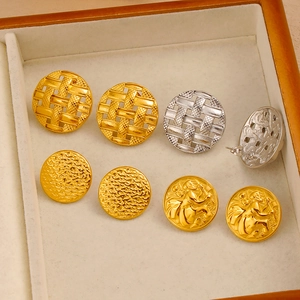 Detail of vintage round earrings with textured relief patterns in gold and silver