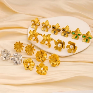 Makroaufnahme von Vintage-Blumenohrsteckern in Gold mit Perlen und bunten Edelsteinen