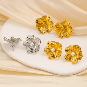 Details von Vintage Blumen-Ohrsteckern mit Perlen auf champagnerfarbenem Satin-Stoff