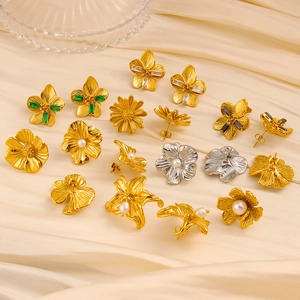 Vintage-Blumenohrstecker-Set mit Perlen und Edelsteinen auf beigem Satinstoff