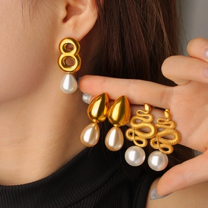 Trois paires de boucles d'oreilles serpent et chiffre huit dorées avec perles blanches
