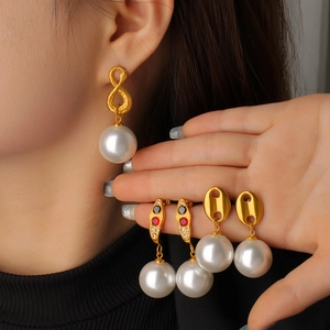 Detailed view of gold 18K plated stainless steel pearl drop earrings worn by a model