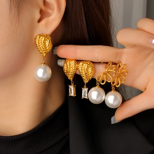 Close-up of vintage gold snake-style pearl earrings with zircon charms for women