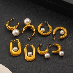 Boucles d'oreilles perles dorées en forme de C avec texture métallique sur fond noir