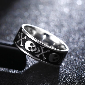 Macro detail of gothic skull crossbones engraving on 8mm wide stainless steel ring band