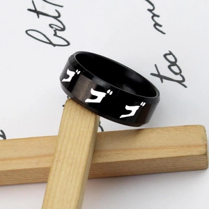 Macro shot of black stainless steel anime ring featuring white Katakana character engraving