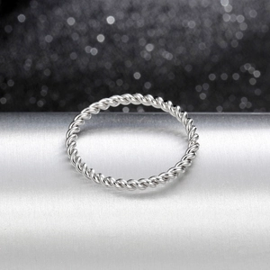 Macro shot of twisted rope design silver ring with elegant lighting on brushed metal