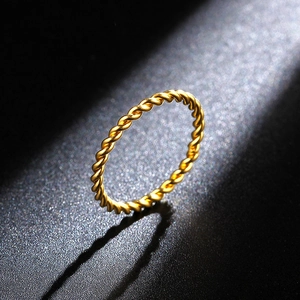 Macro shot of an 18K rose gold twisted rope ring with elegant metallic texture and light