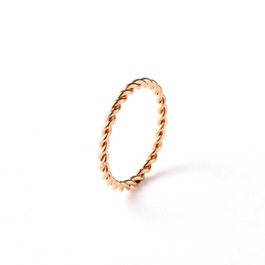 Macro shot of 18K rose gold twisted rope ring showing the elegant metallic texture