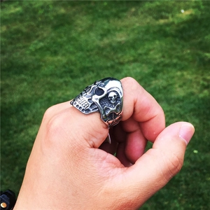 Relieve detallado de la Parca en un anillo de calavera plateado vintage usado en la mano