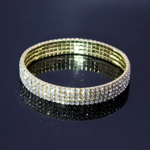 Gros plan macro du bracelet de tennis doré brillant à trois rangées de strass