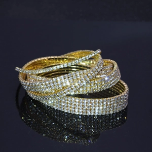 Détail d'un bracelet de mariée doré multicouche avec cristaux étincelants sur fond noir
