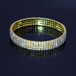 Détail d'un bracelet de mariée en alliage doré avec trois rangées de cristaux blancs