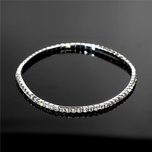Vue macro d'un bracelet de cheville de mariée avec une rangée de cristaux sur miroir noir