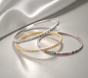Détail de bracelets de cheville extensibles à une rangée en argent, or et cristaux colorés
