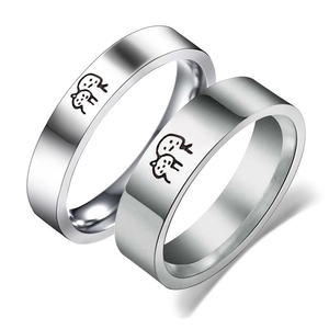 Polished stainless steel couple rings set with minimalist black cartoon character engravings
