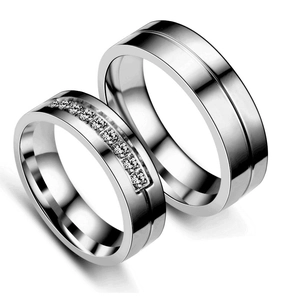 Detail view of silver stainless steel couple rings with rows of embedded zircons