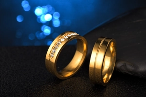 Macro shot of gold couple rings featuring micro-pave crystals and sleek groove detail