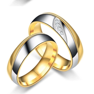 Makro-Detail von zweifarbigen Edelstahl-Partnerringen mit diagonalen Diamant-Akzenten