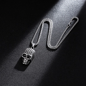 Collar con colgante de calavera gótica en acero inoxidable plateado sobre fondo negro mate