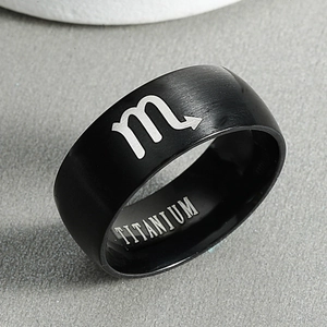 Macro shot of black titanium ring featuring Scorpio zodiac sign and inner engraving