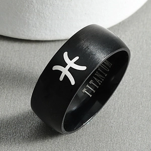 Macro shot of black titanium steel Pisces zodiac ring with matte finish and engraving