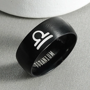 Detailed macro view of black matte titanium ring featuring engraved Libra zodiac symbol