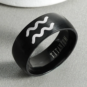 Macro shot of black titanium Aquarius ring featuring brushed finish and silver wave engraving