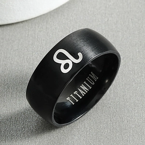 Detail of black titanium ring featuring silver Leo zodiac symbol and brushed metal finish