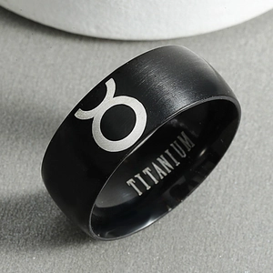 Macro detail of black matte titanium ring showing the Taurus zodiac sign and inner engraving
