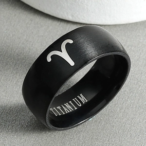 Detailed close-up of a black titanium Aries zodiac ring with a matte brushed finish