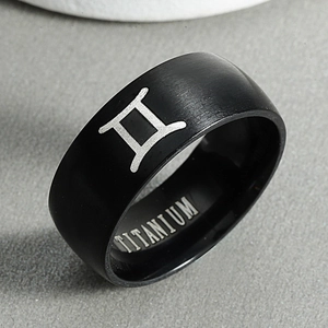 Macro detail of black matte titanium ring with engraved Gemini constellation symbol