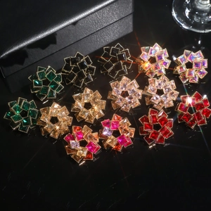 Sparkling zircon flower earrings in multiple colors on a premium black mirror display stand
