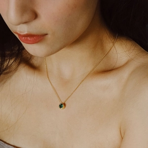 Collier en acier inoxydable doré avec un pendentif rond serti d'une pierre vert foncé