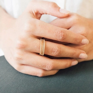 Detail of three stacked 14K gold plated eternity rings with sparkling white crystals
