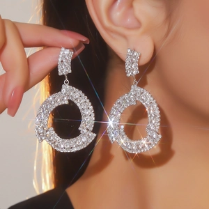 Dettaglio di orecchini a cerchio in argento con strass scintillanti su modella