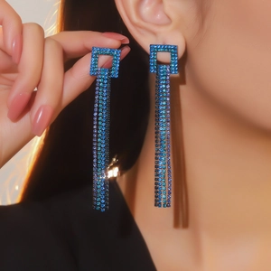 Dettaglio orecchini a nappa blu con pavé di strass e frange lunghe luccicanti