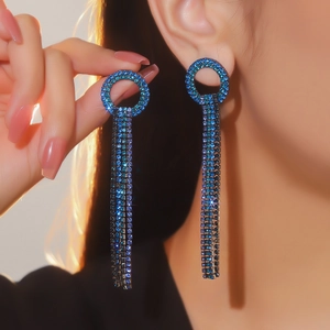 Dettaglio di orecchini a cuore di lusso con cristalli blu e lunghe nappe a frangia