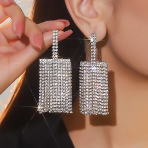 Primo piano di orecchini a cascata in argento con strass scintillanti su modella